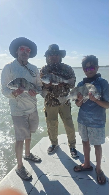 Happy clients showing off their catch with Capt. Rey on the bay
