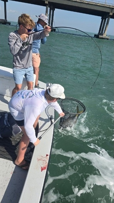 Capt. Rey netting a fish during a hookup