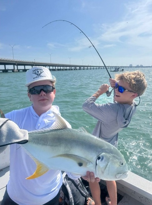 Kids celebrating a big catch together on the boat