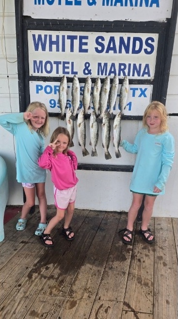 Kids showing off their fish after a family trip