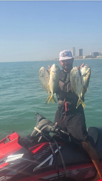 Angler displays four fish on a personal watercraft.