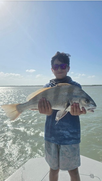 Angler holds a fish on the boat.
