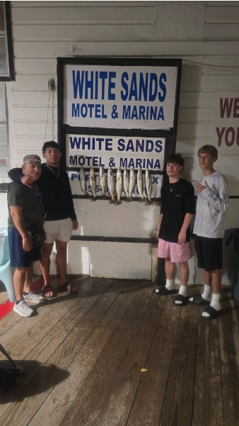 Group poses with fish on the cleaning board.