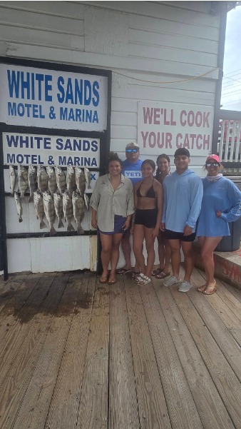 Group poses beside a full fish display board.