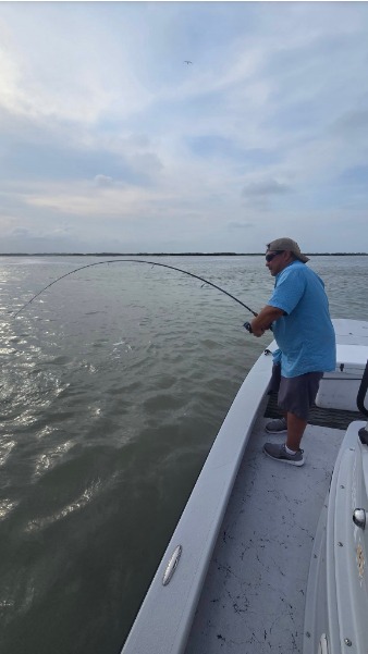 Angler fights a fish from the bow.