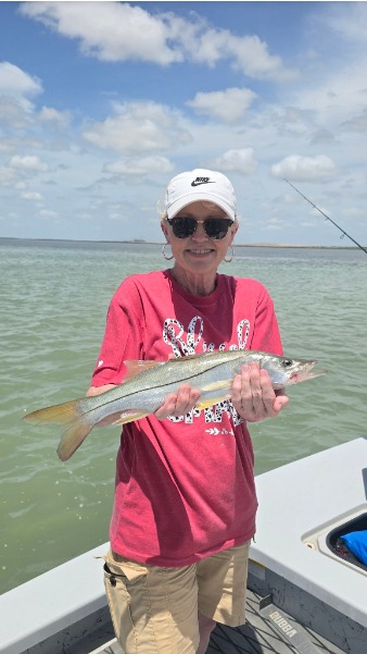 Angler holds a fish by the marina.