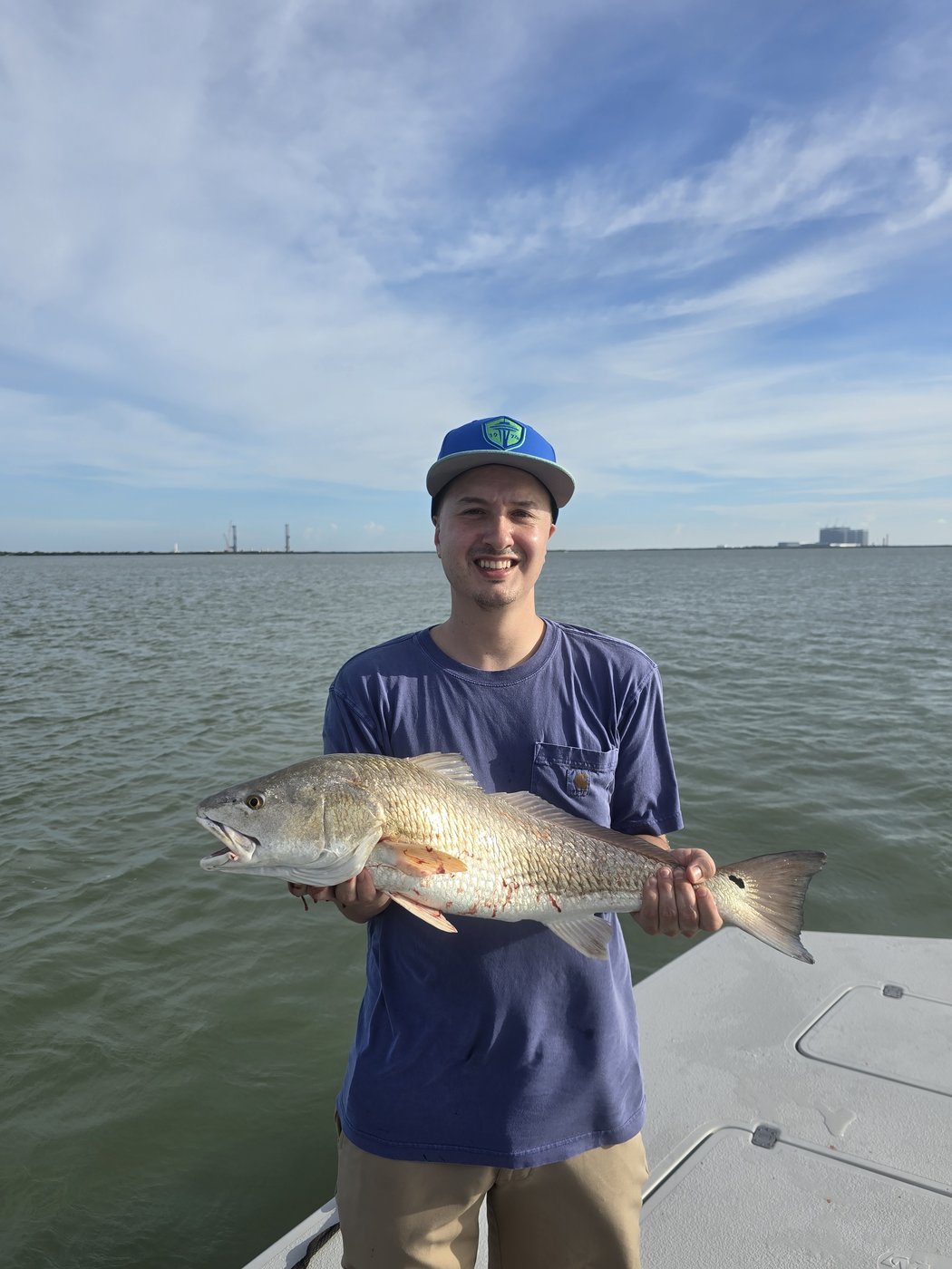 Angler holding a large redfish on the boat